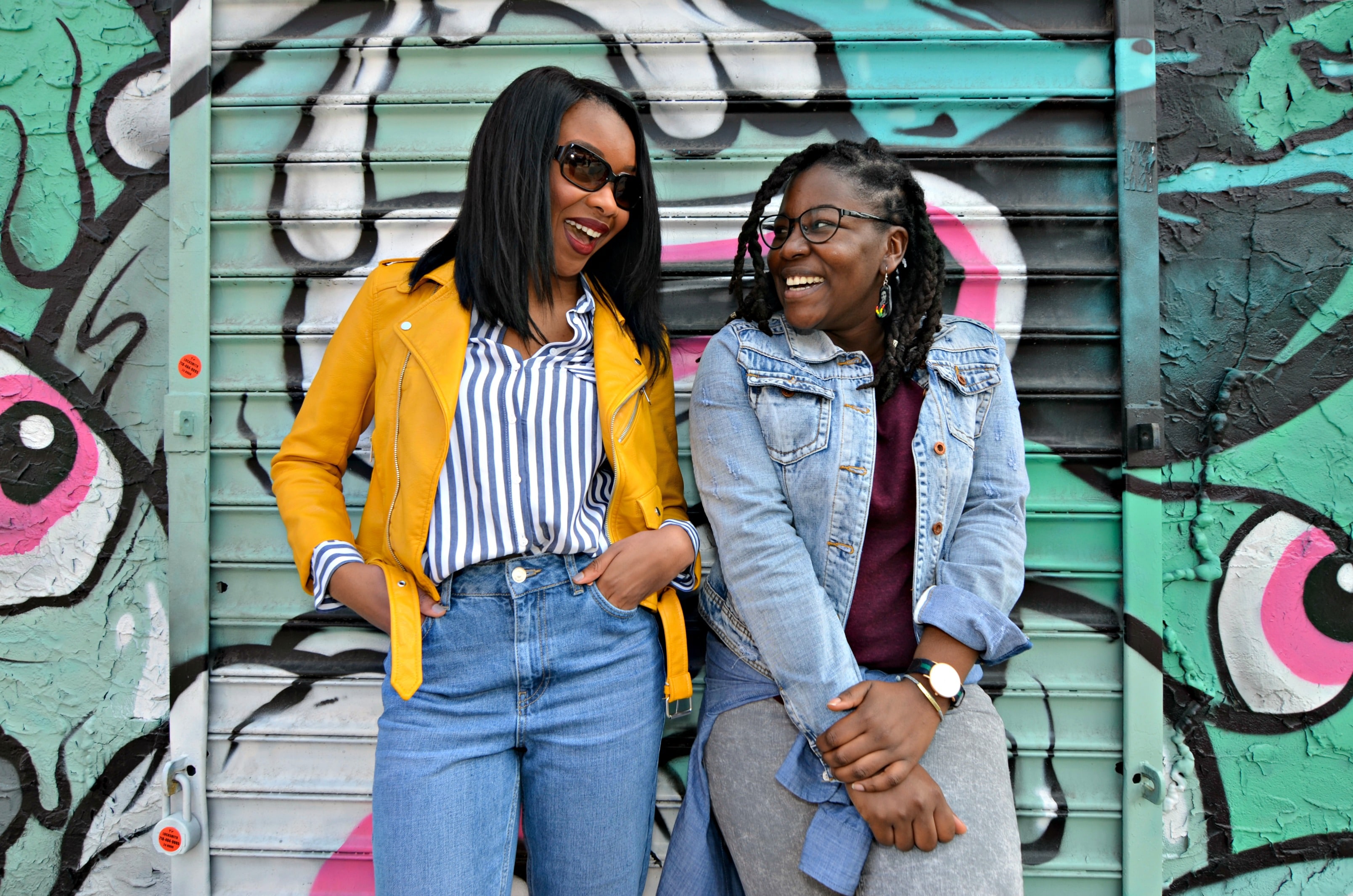 two women posing in front of street art on a New York City photo tour