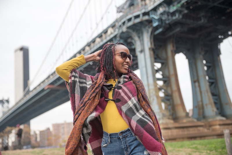 female influencer posing with an NYC bridge in the background