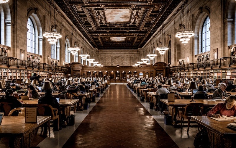 peeople reading at tables in the New York Public Library