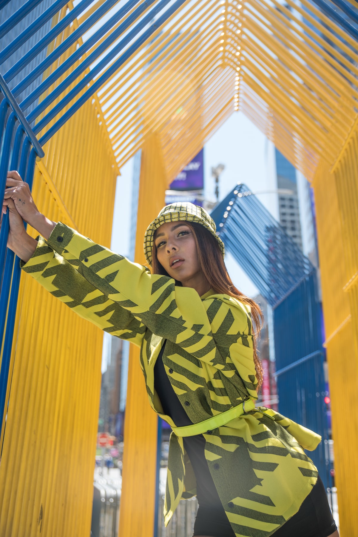 female influencer in a yellow jacket posing for photos in Times Square